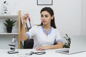 beautiful doctor looking blood sample